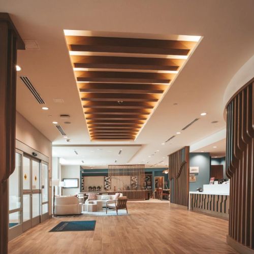 A modern, spacious lobby with warm wood accents, soft seating, and a bright reception area. It feels inviting and contemporary.